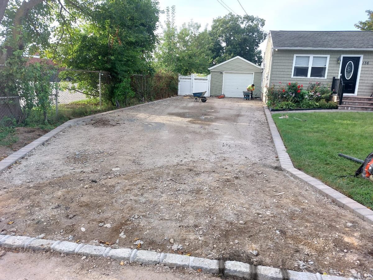A gravel driveway is being built in front of a house.