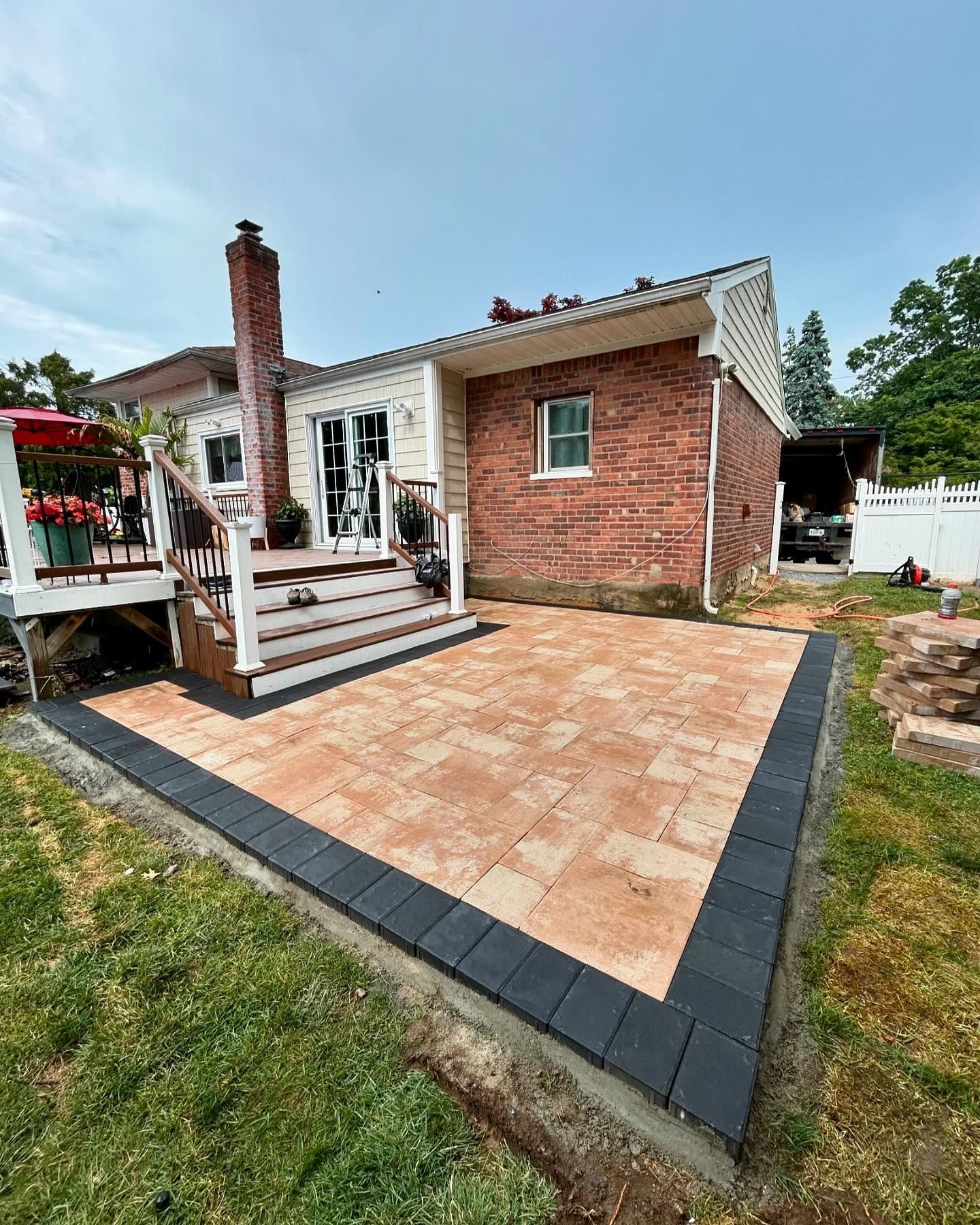 A brick house with a patio and stairs in front of it.