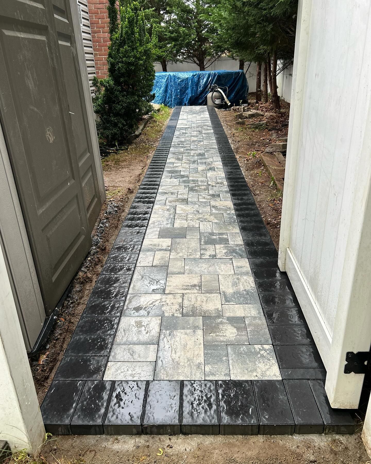 A black and white brick walkway leading to a garage door.