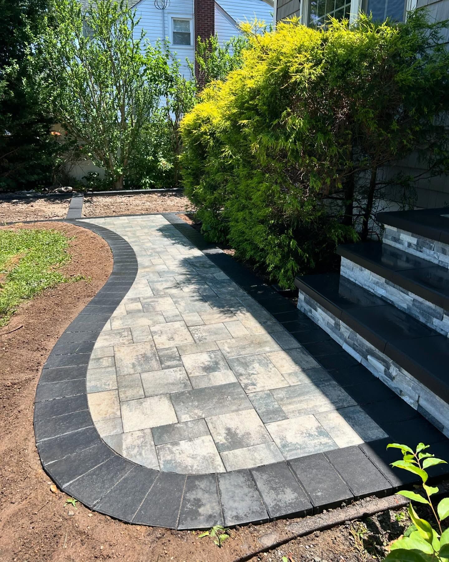 A curved walkway with steps leading to a house.