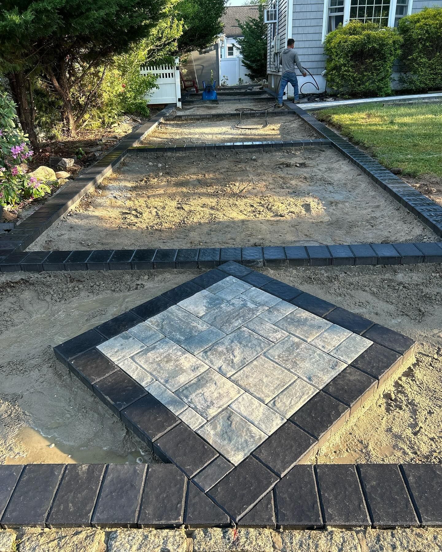 A brick walkway is being built in front of a house.