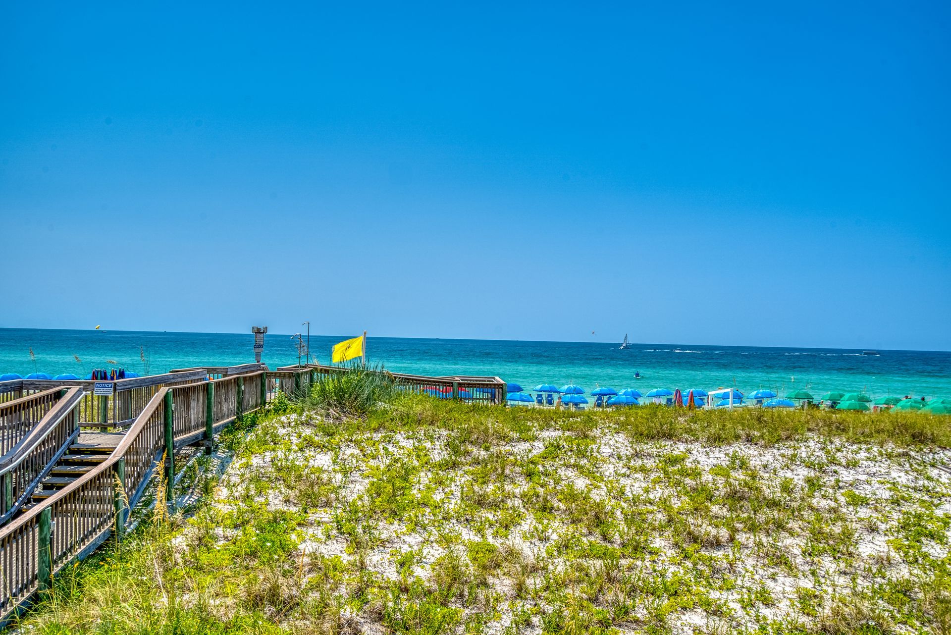 There is a wooden walkway leading to the beach.