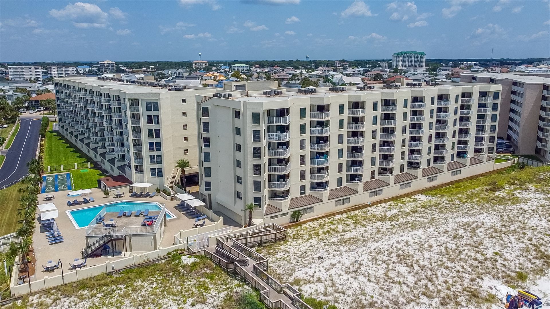 An aerial view of a large apartment building with a swimming pool.