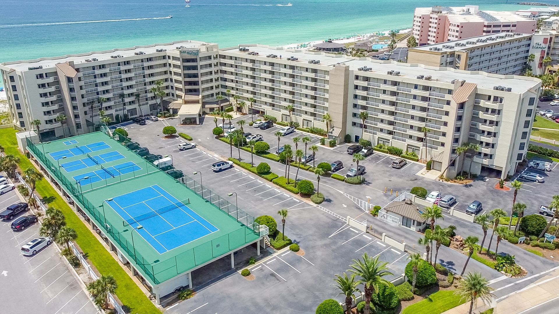 An aerial view of a tennis court in front of a large building.