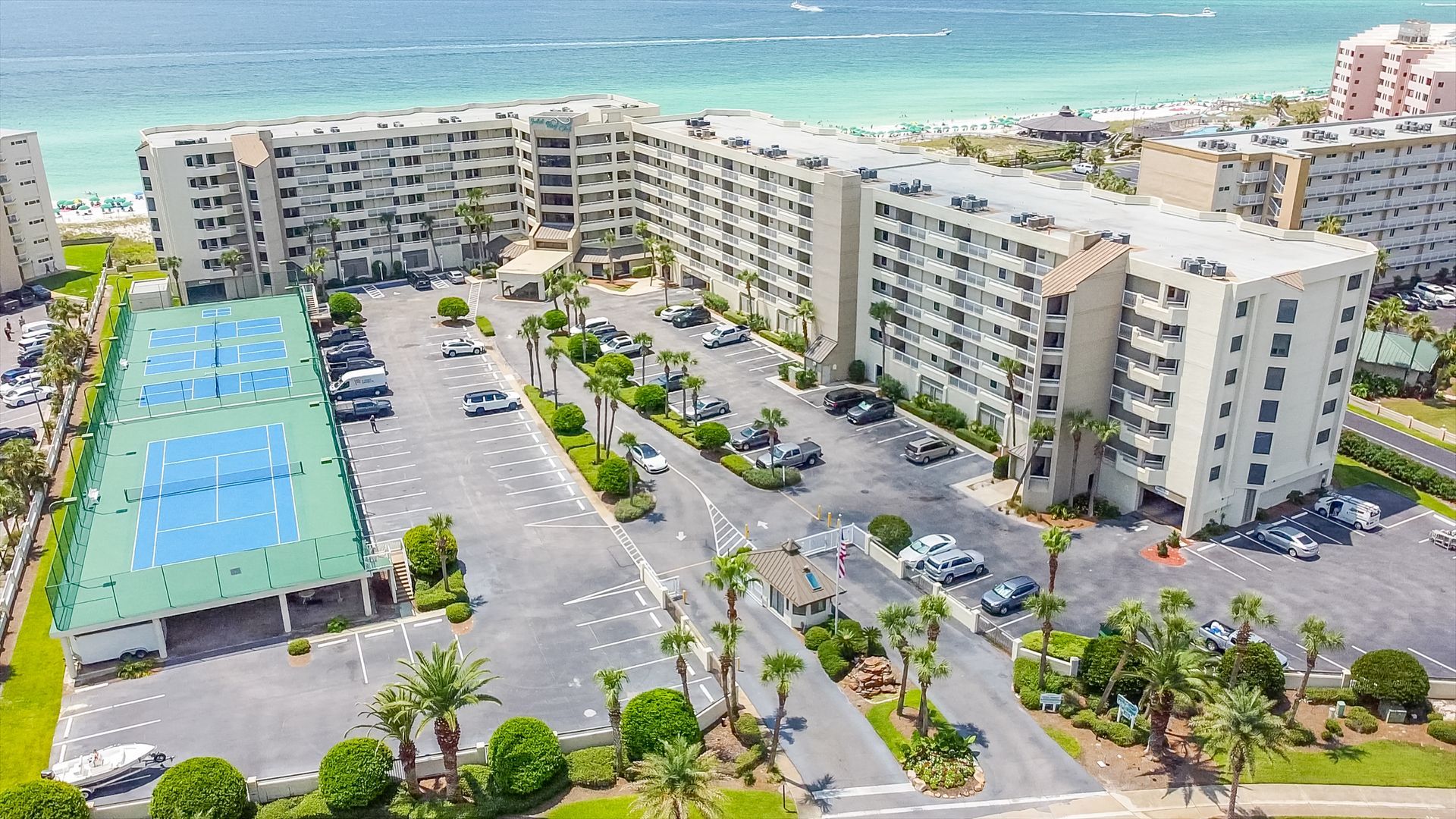 An aerial view of a large apartment complex with a tennis court.