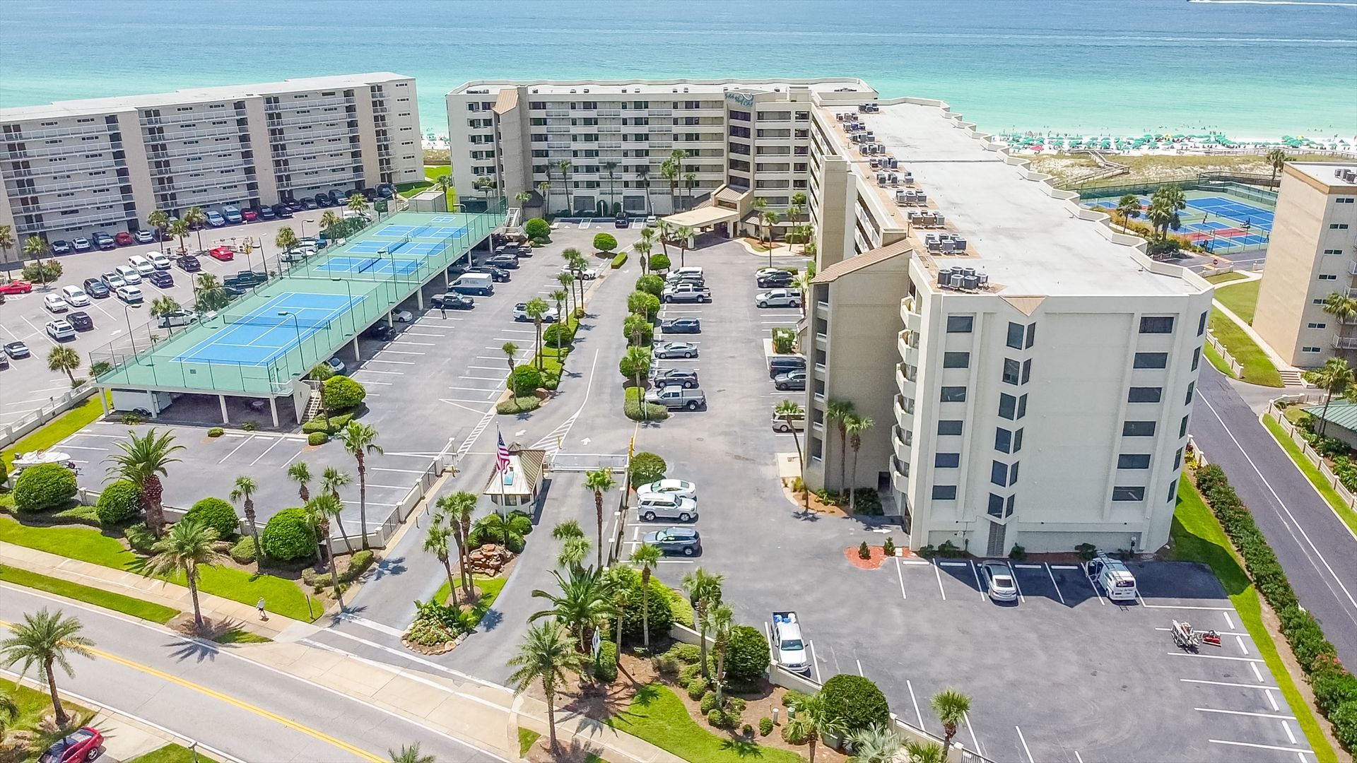 An aerial view of a hotel with a lot of cars parked in front of it.