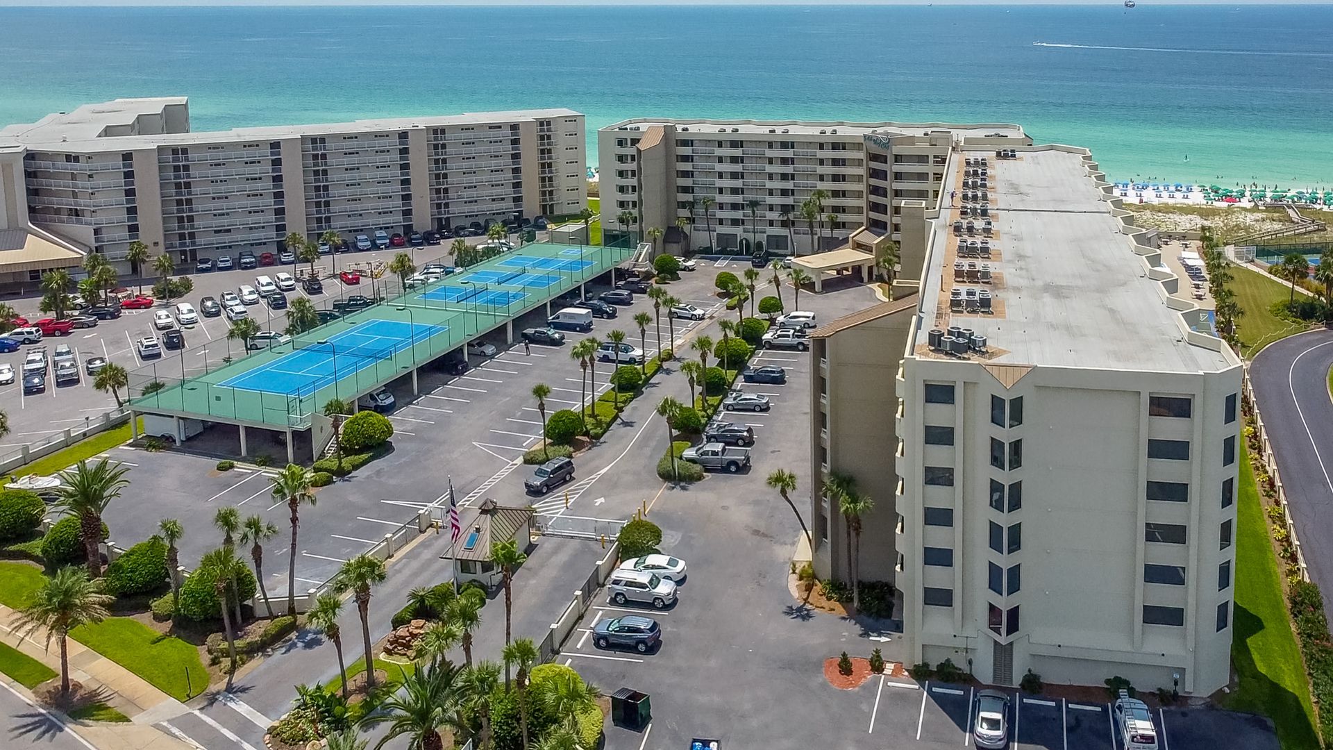 An aerial view of a large building with cars parked in front of it.