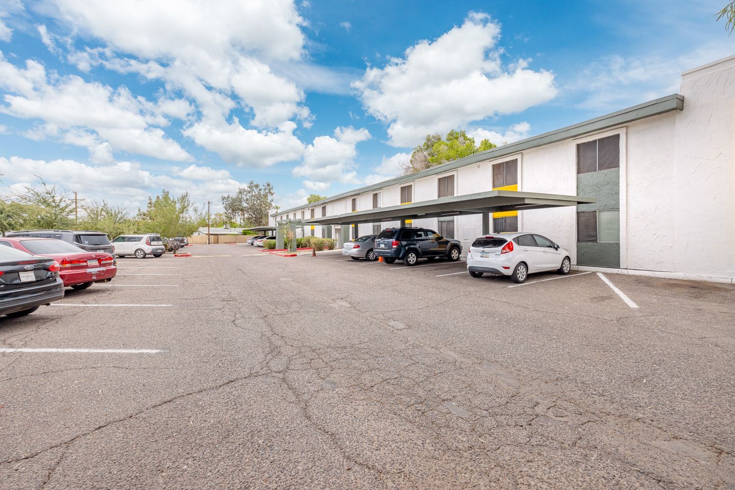 several cars are parked in a parking lot in front of a building