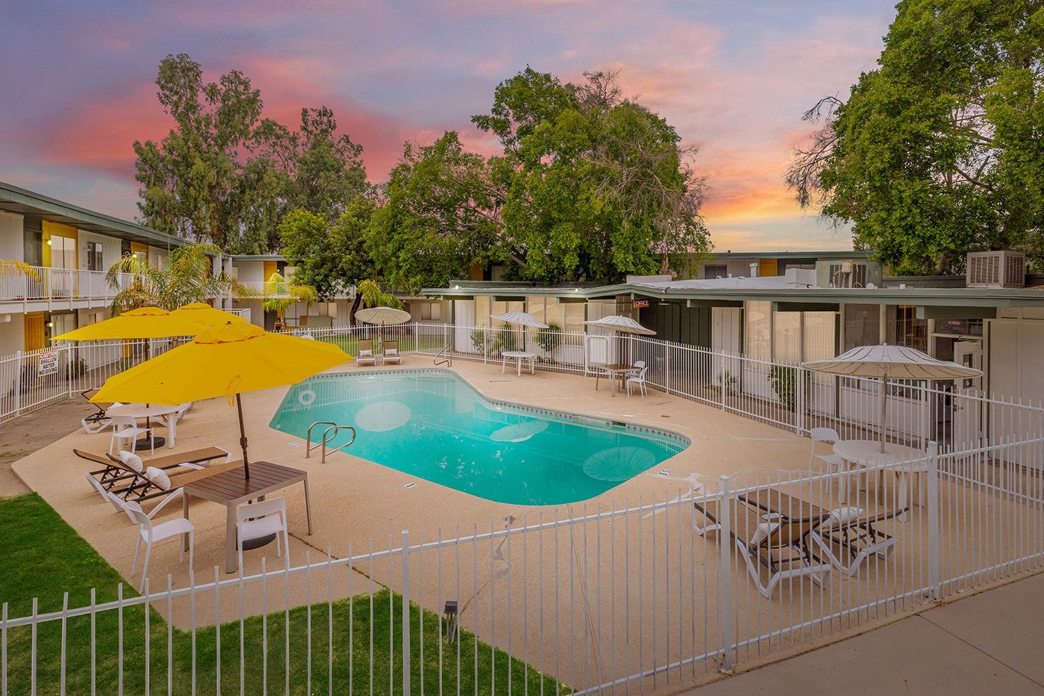 a large swimming pool surrounded by chairs and umbrellas