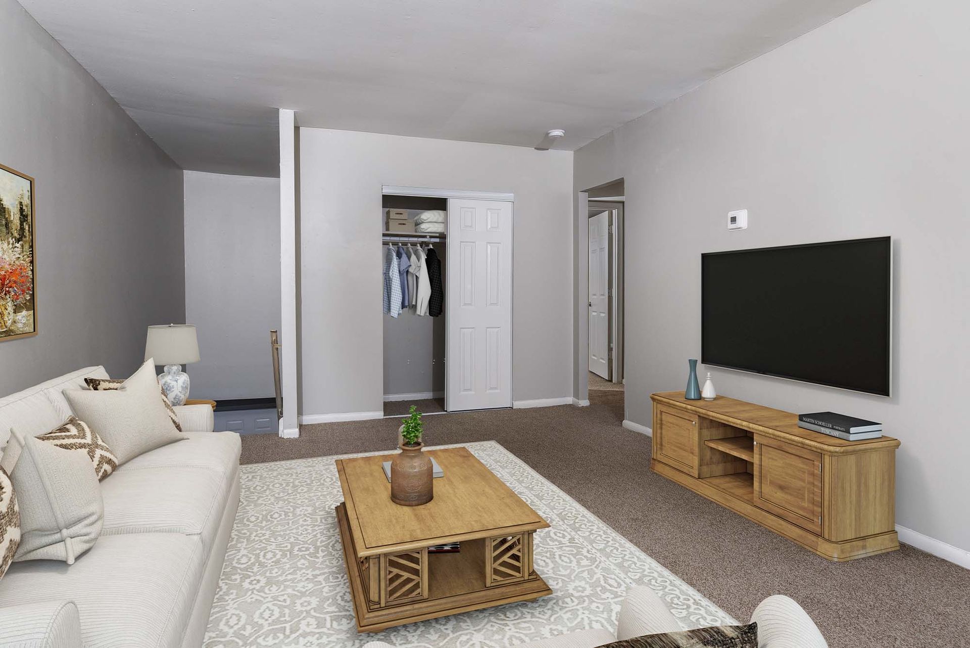 Interior living room of an apartment with gray walls, beige sofa, wooden coffee table, rug, closet, and TV.