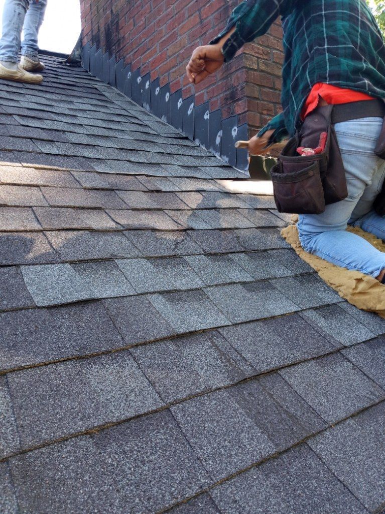 a man working on a roof with a tool belt