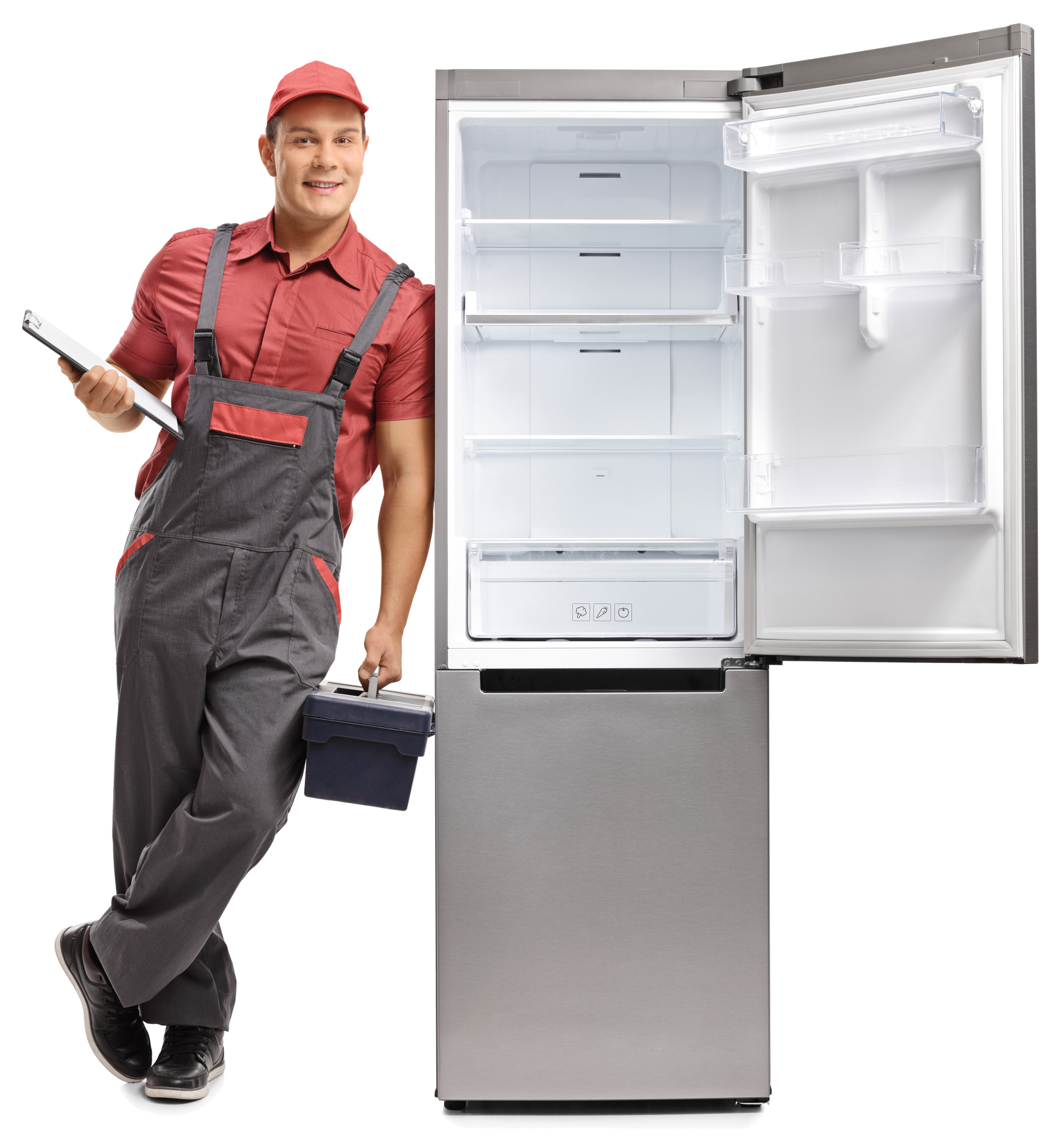 Refrigerator repairman in overalls and cap, standing by an open, empty stainless steel refrigerator.