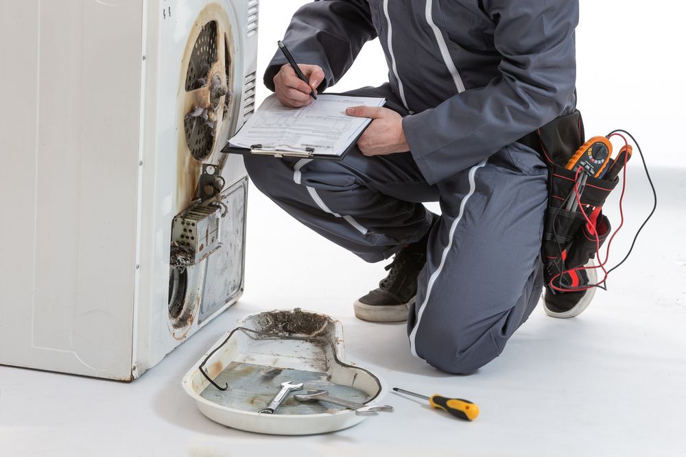 Repair person inspecting a damaged appliance, writing on a clipboard; tools nearby.