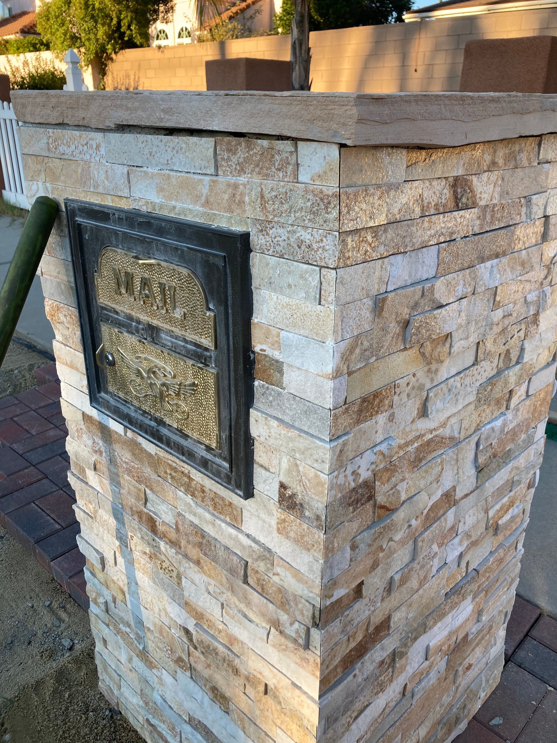 A brick wall with a mailbox on the side of it.