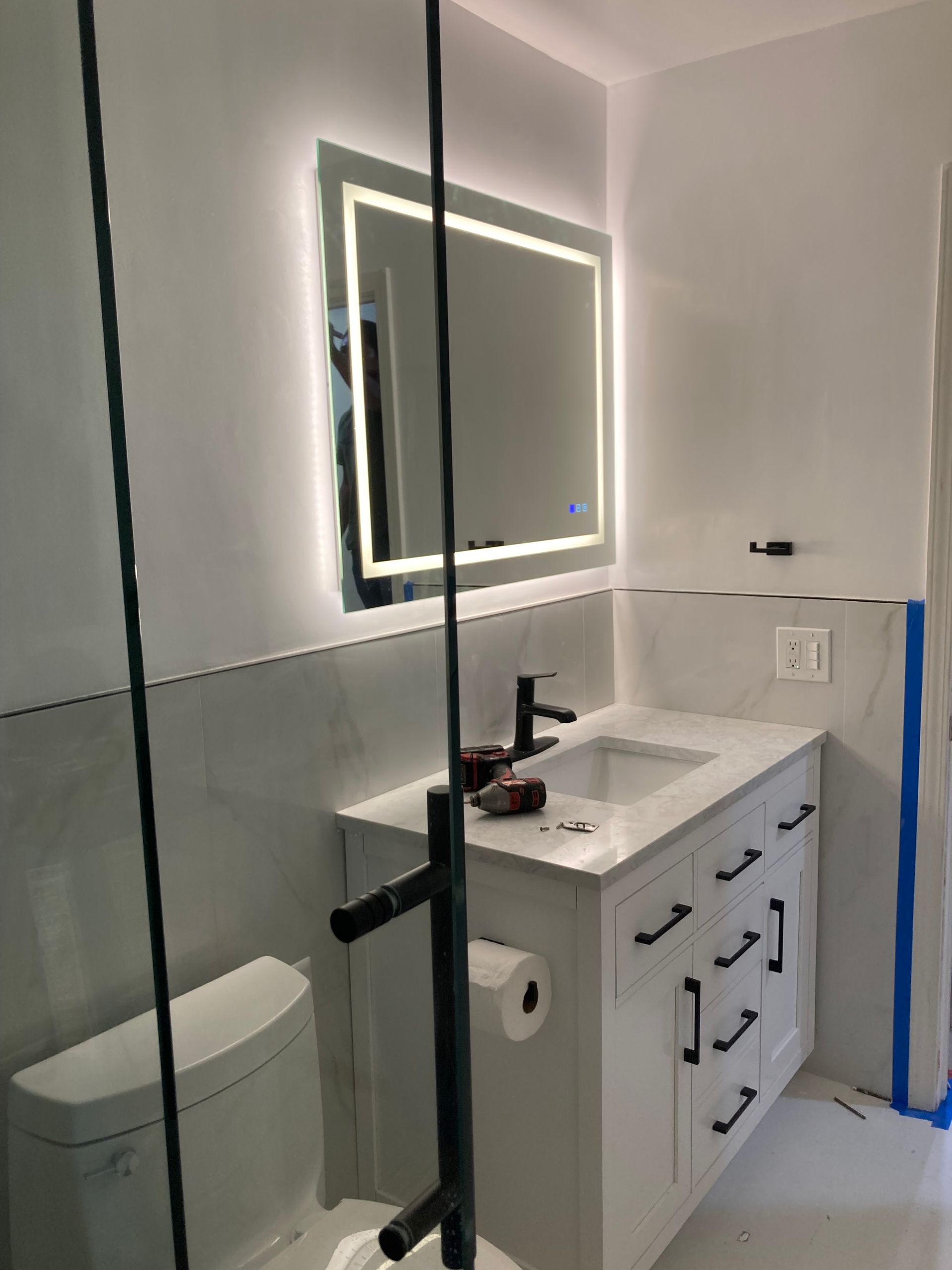 A bathroom with a sink , toilet and mirror.