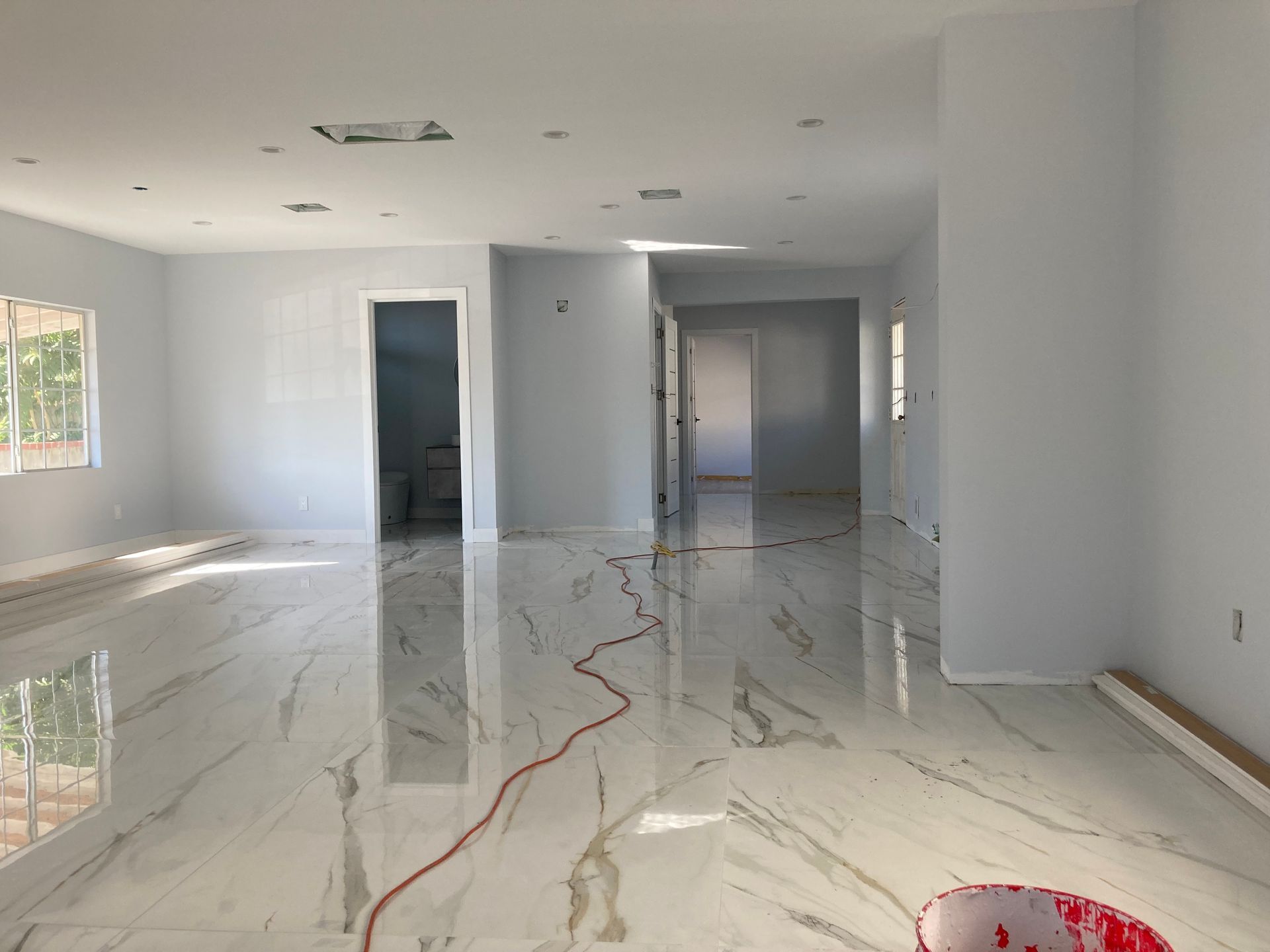 A large empty room with a marble floor and white walls.
