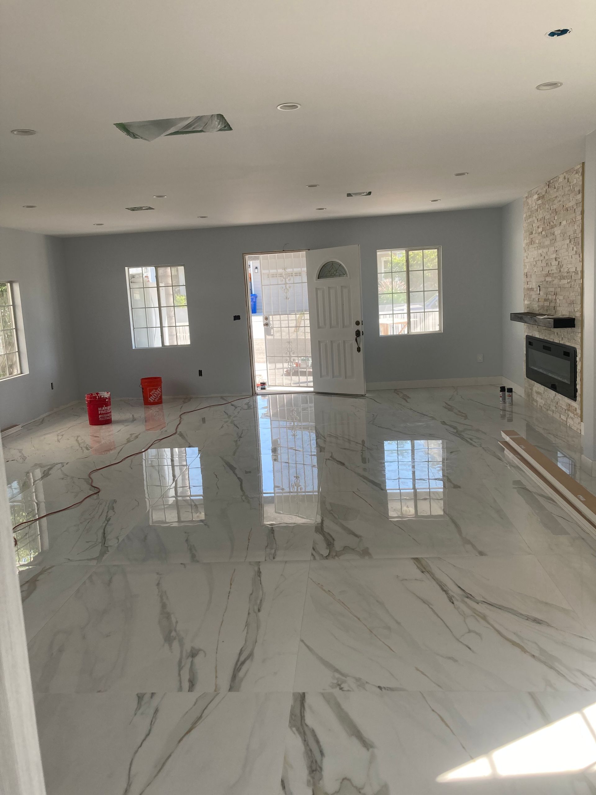 A large empty room with marble floors and a fireplace