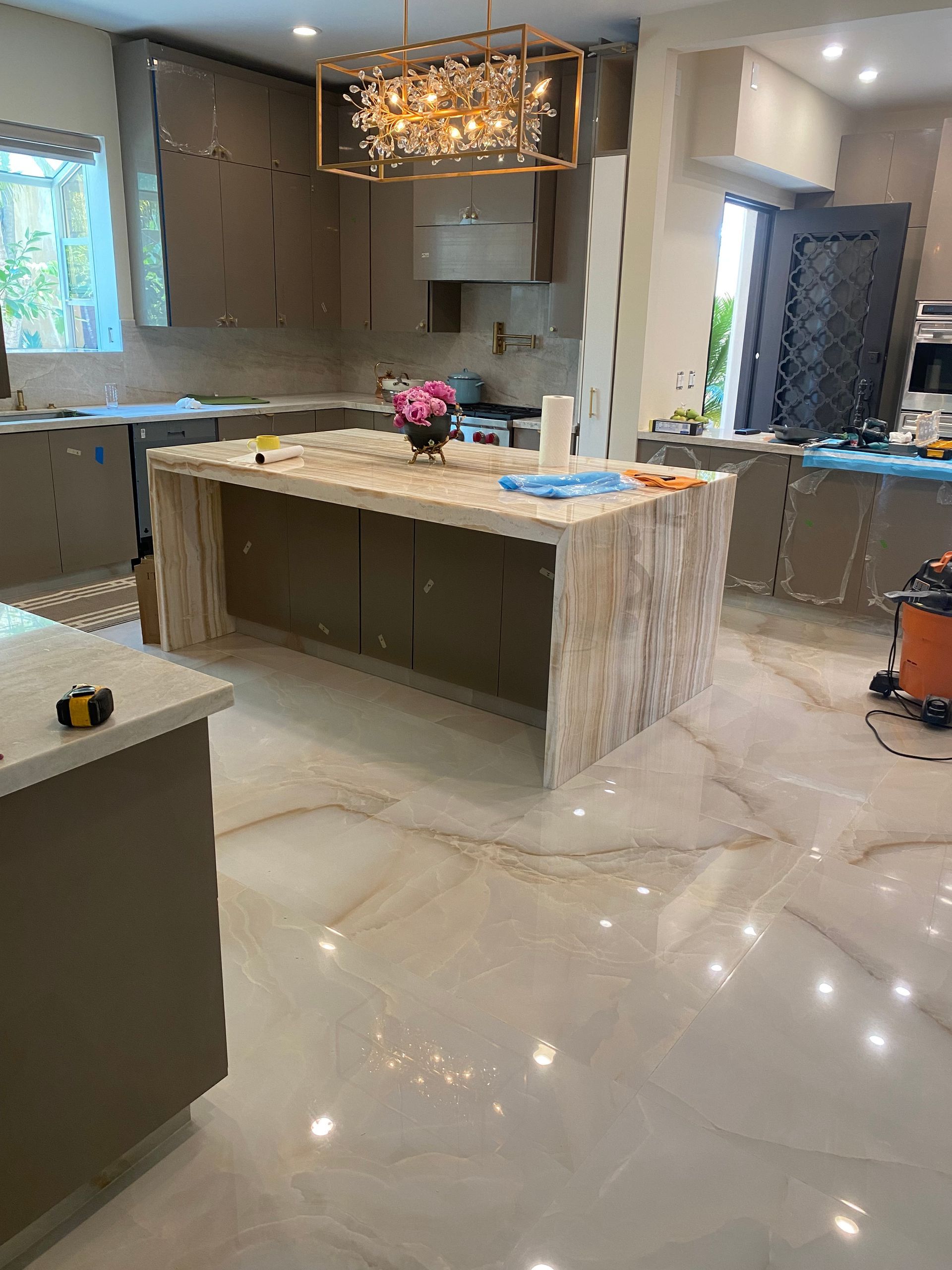 A kitchen with a large island and a chandelier.