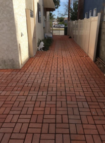 A brick walkway with a dog on the side of it