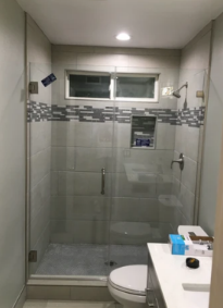 A bathroom with a toilet and a shower with a glass door