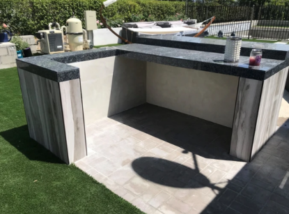 An outdoor kitchen with a candle on top of it