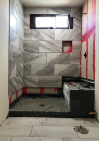 A bathroom under construction with tiles and a window