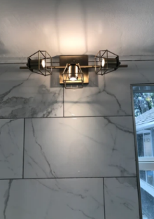 A light on a tiled wall with a window in the background