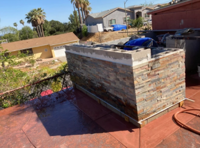 A brick wall is being built on the roof of a house.