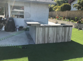 A hose is laying on the grass in front of a house