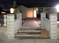 A house with stairs leading up to it is lit up at night.