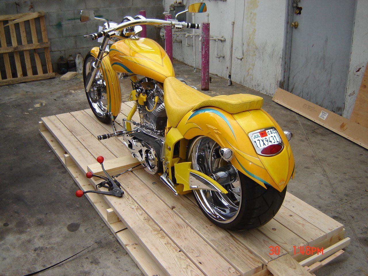 Yellow custom motorcycle on wooden pallets.