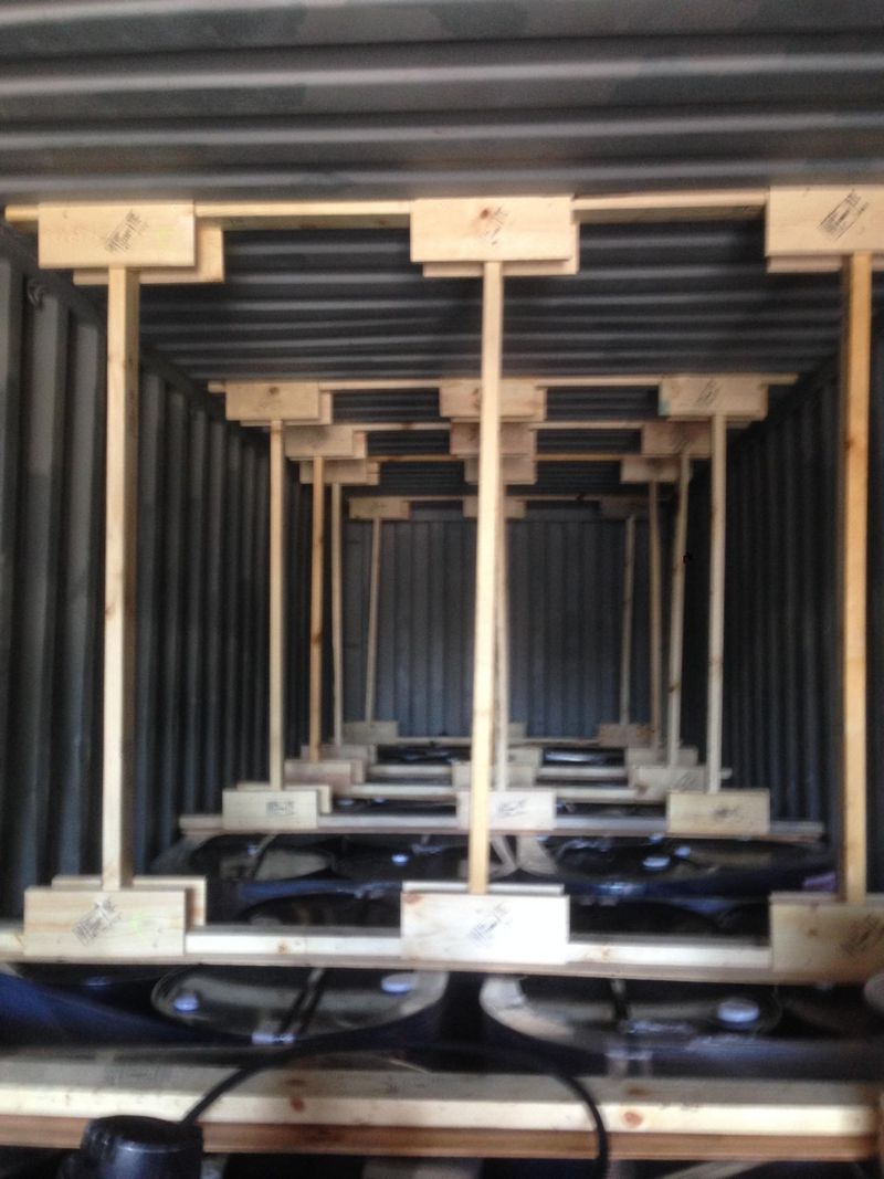 Interior of a shipping container with wooden supports holding packed items.