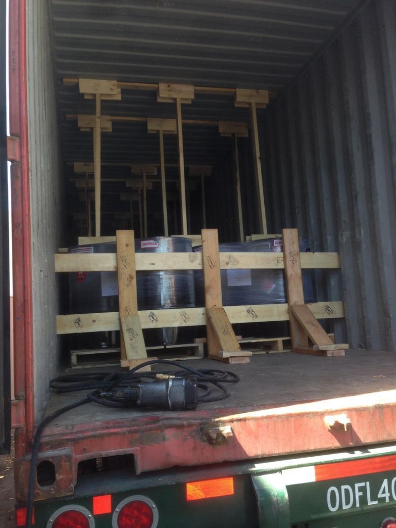 Shipping container filled with wooden crates holding objects, possibly glass panels.