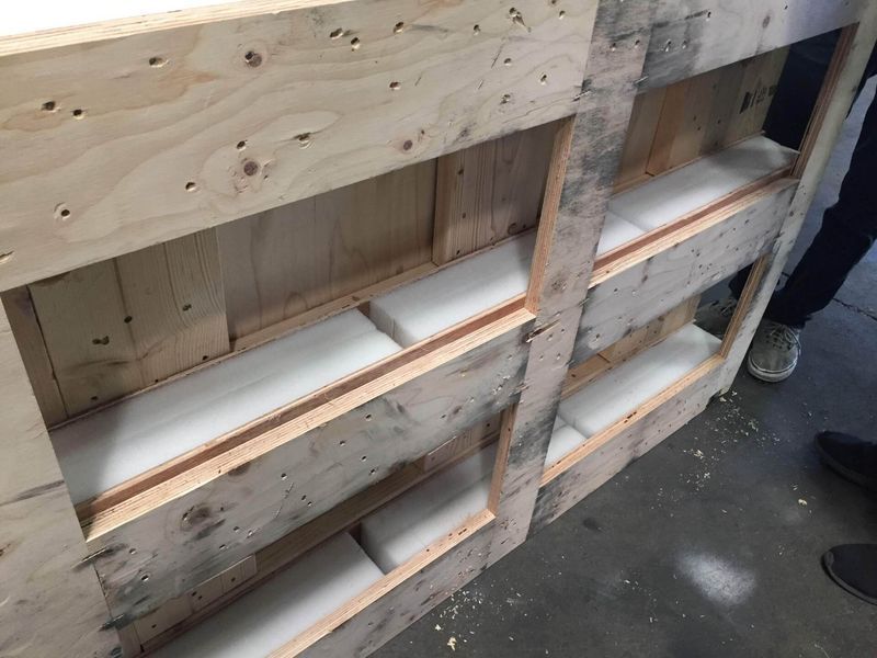 Wooden crate with foam padding, likely for protecting contents during shipping.