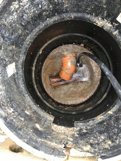 A close up of a hole in the ground with a pipe in it.