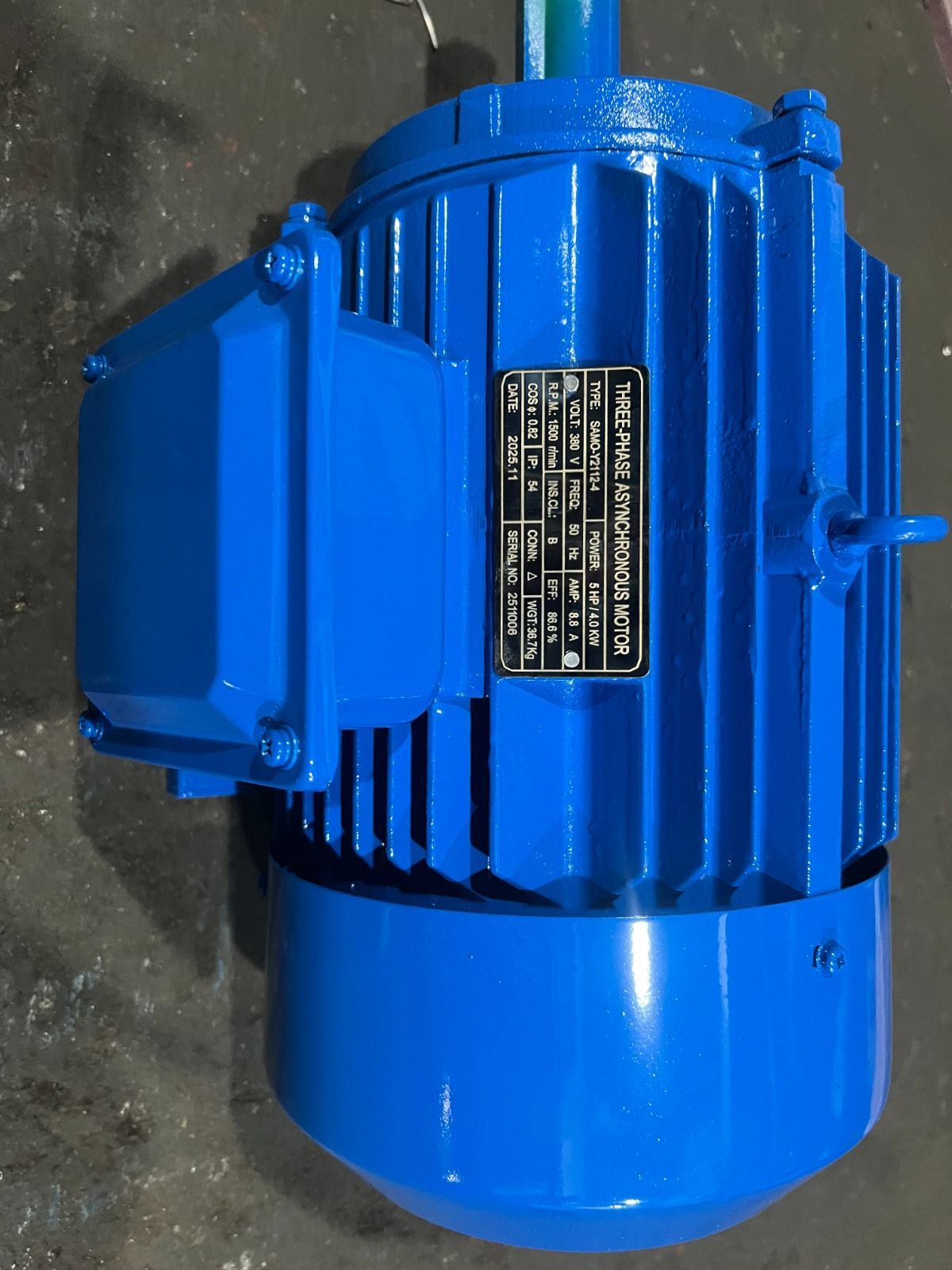 Motor eléctrico azul con caja de conexiones rectangular y placa de datos.
