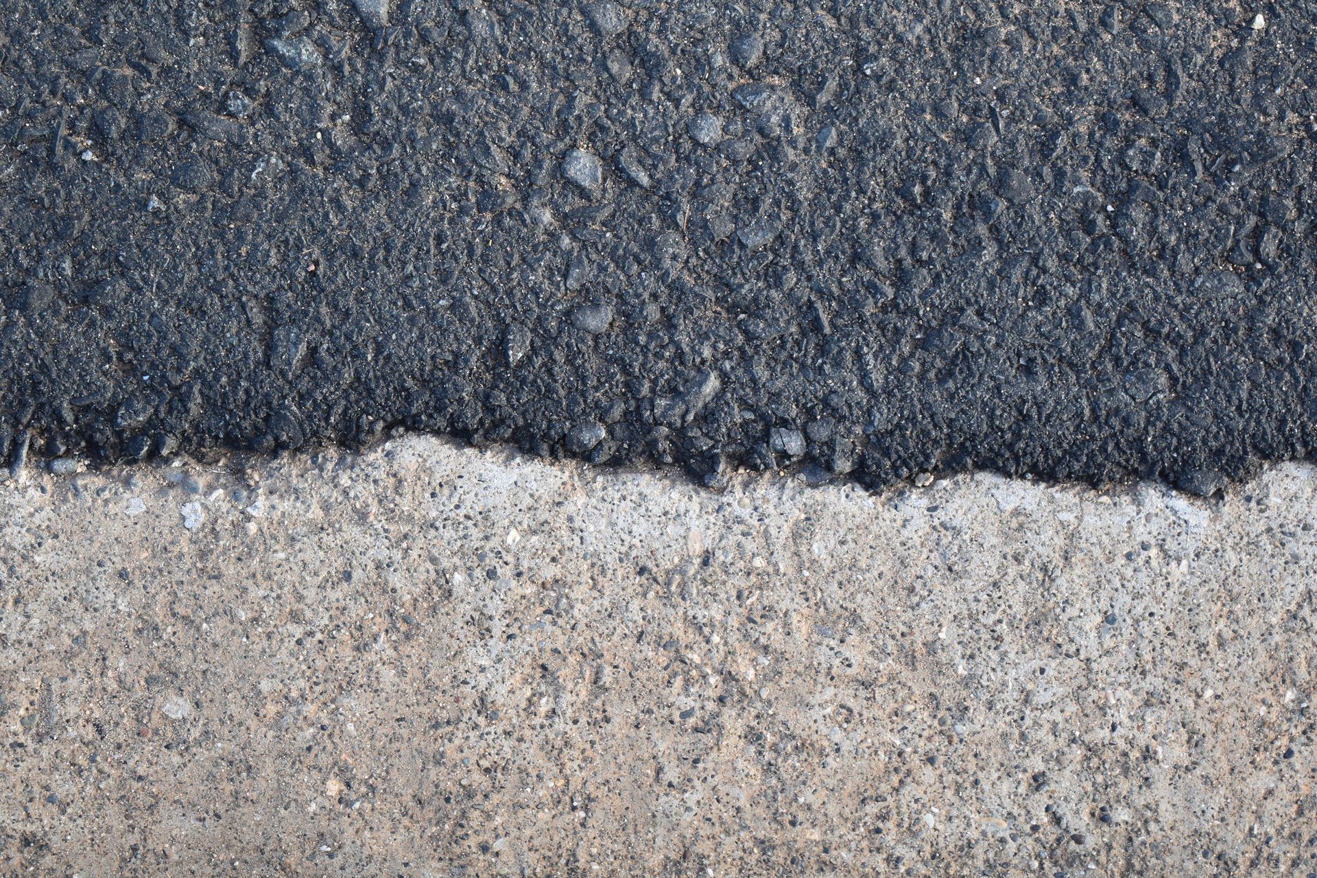 A close up of a concrete and asphalt surface.