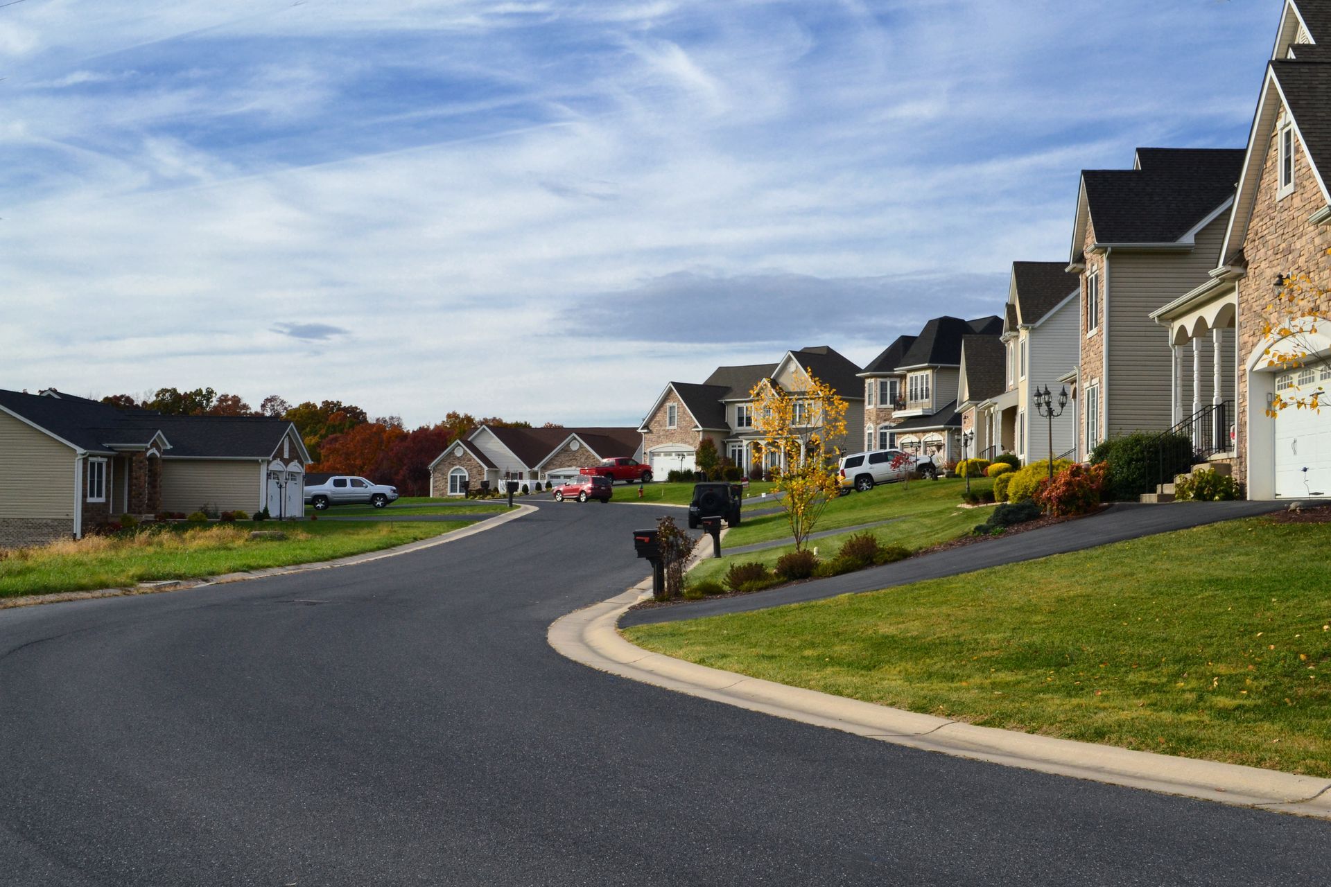 A row of houses on a residential street with a mailbox on the side of the road.