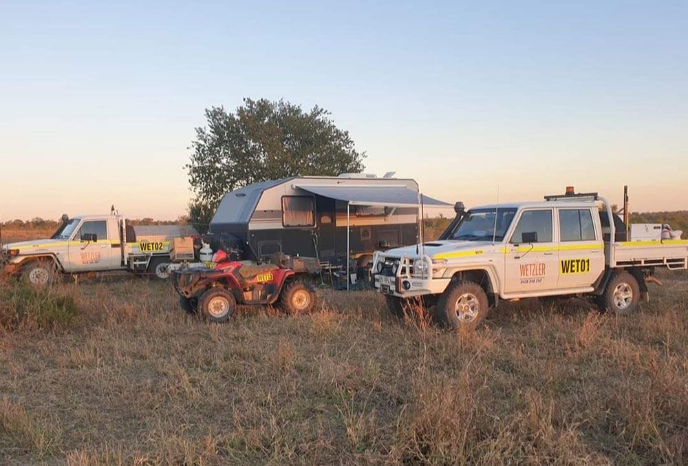 Three Trucks And A Trailer Are Parked In A Field — Wetzler Pty Ltd In Marmor QLD