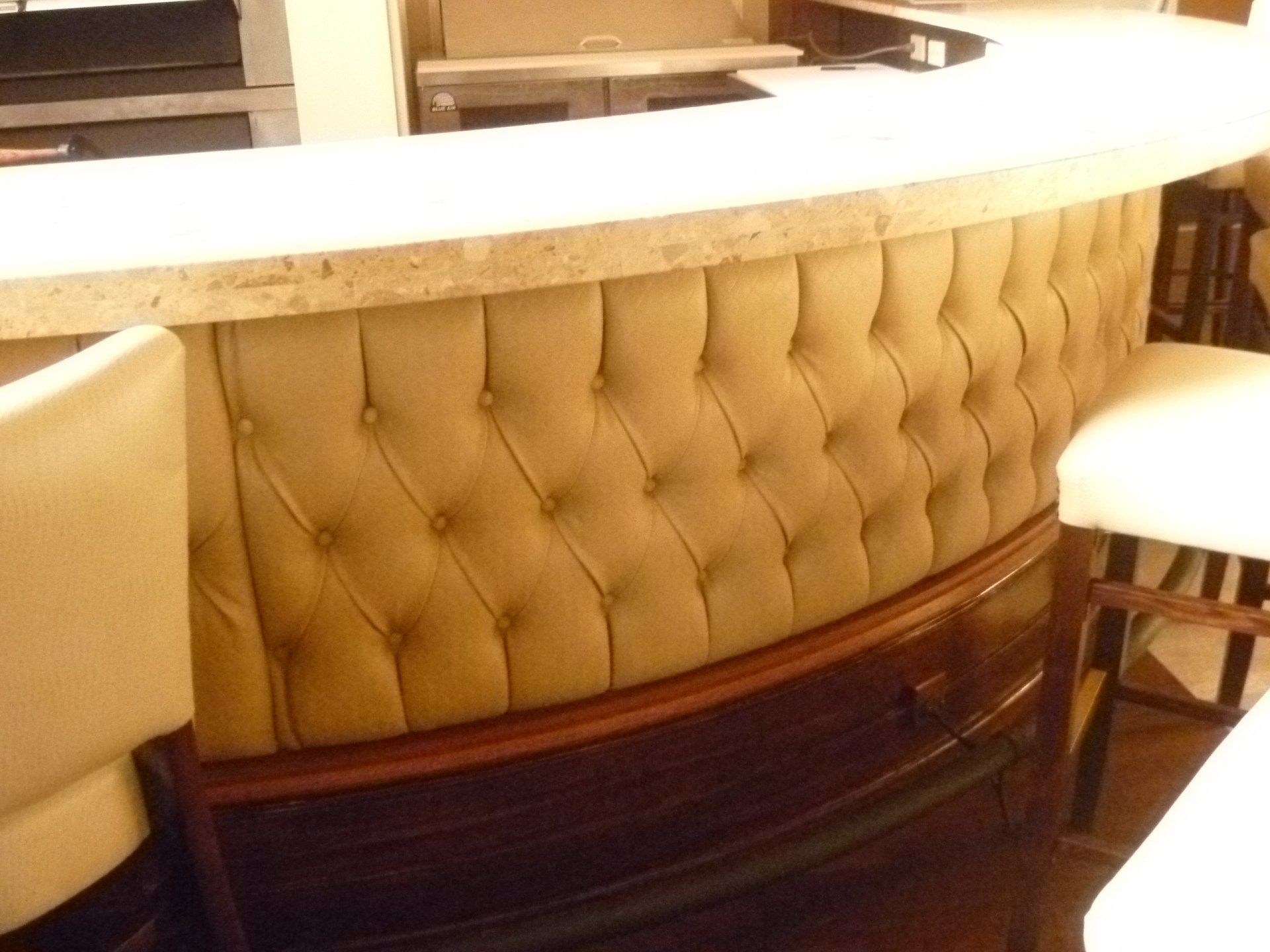A bar with a tufted back and a marble counter top
