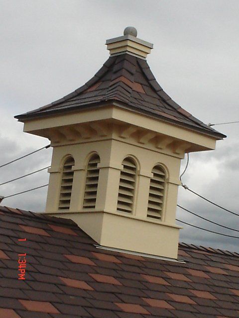 A chimney on top of a roof with a cloudy sky in the background