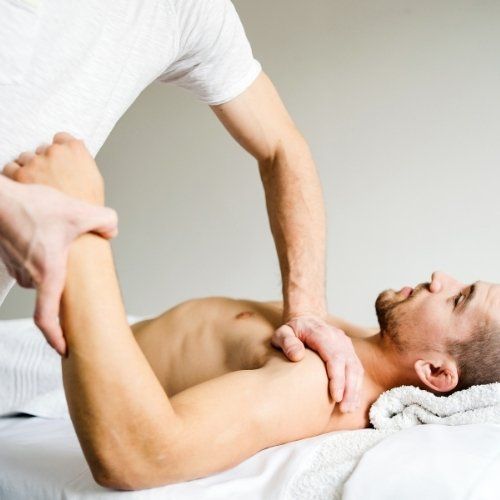hands massaging a man's shoulder