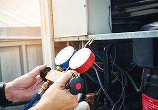 Technician is checking air conditioner — heater repair in Tampa, FL