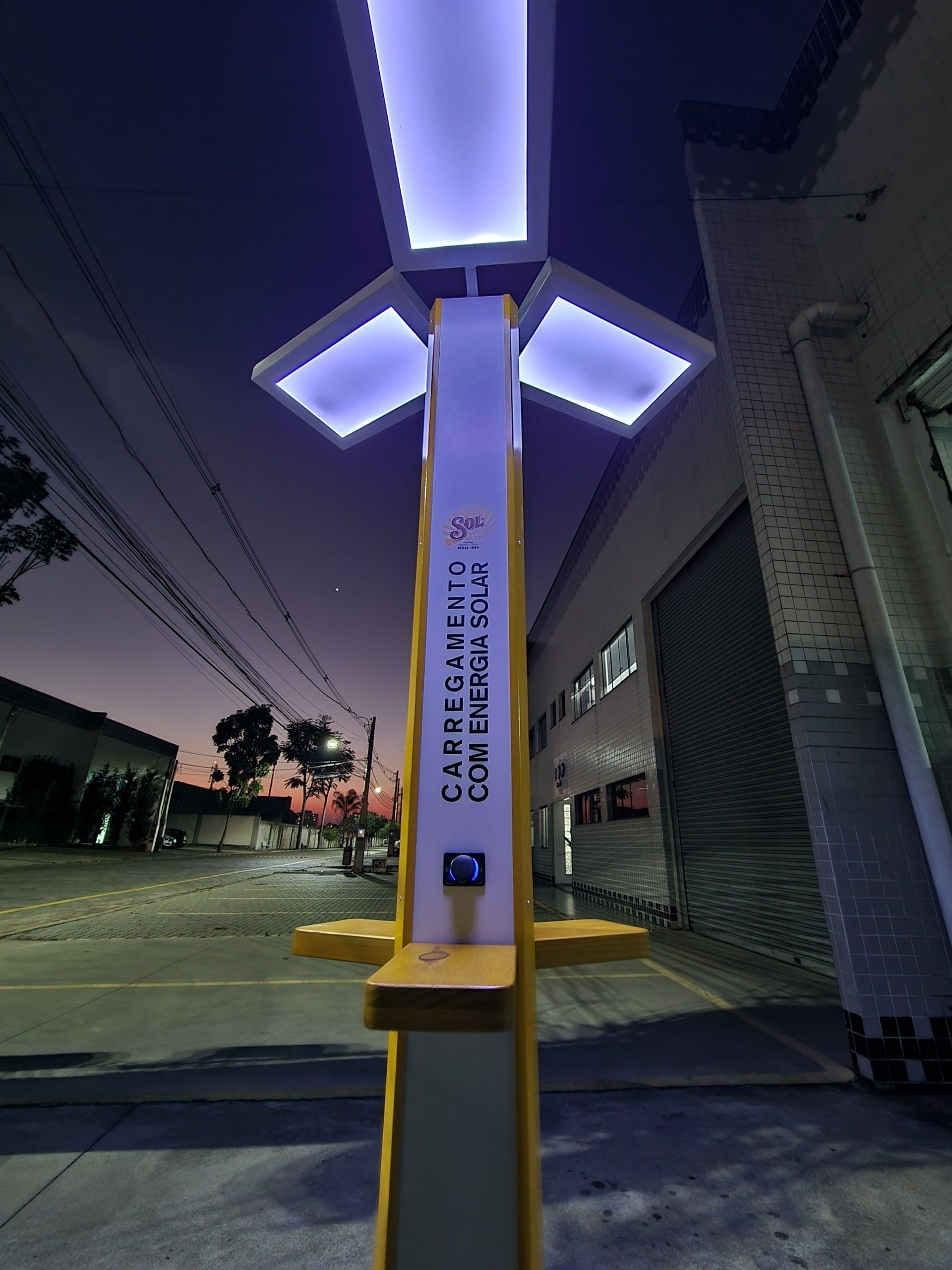 Um poste amarelo e branco com luzes roxas nele