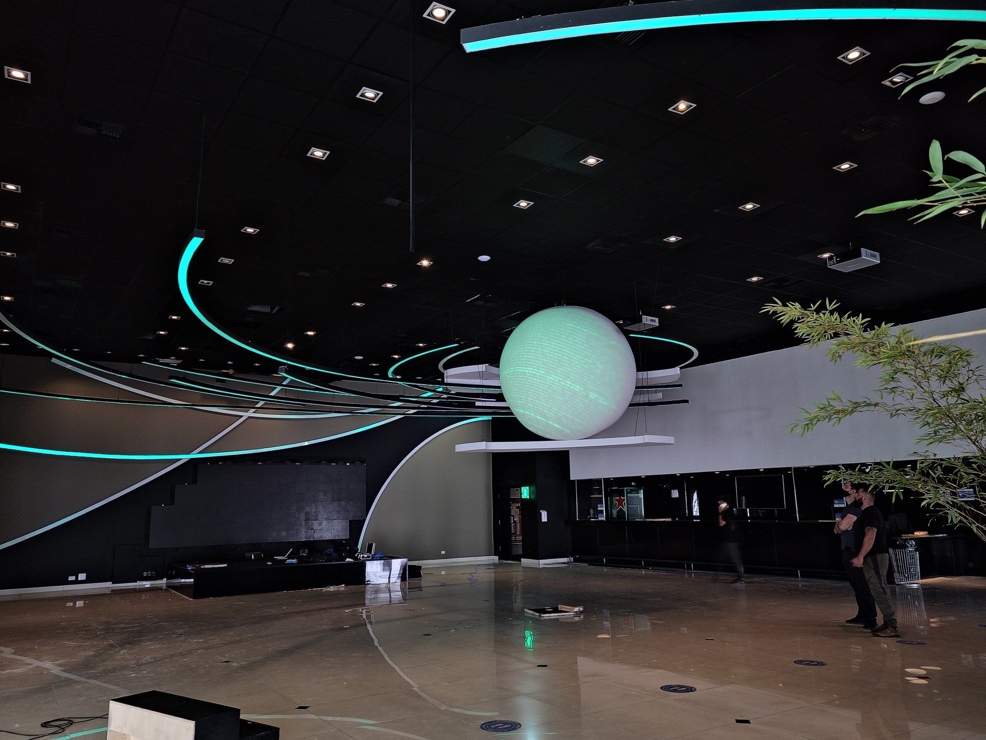 Uma grande esfera verde está pendurada no teto de uma sala