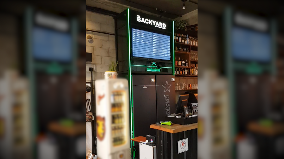 Um bar com uma tela grande na parede.