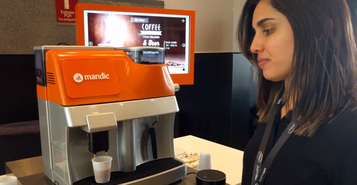 Uma mulher está parada em frente a uma máquina de café laranja.