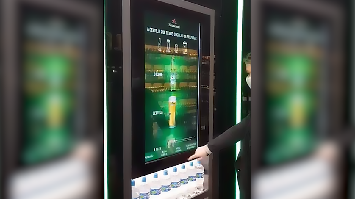 Uma pessoa está apertando um botão em uma máquina que parece um celular.