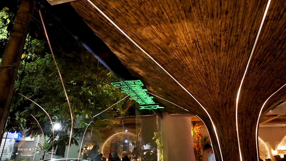 Um prédio com uma árvore no meio é iluminado à noite.