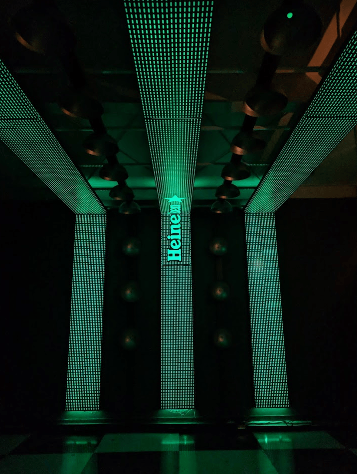 Uma placa da Heineken está acesa em um quarto escuro